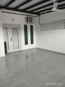 峇株巴轄的住宿－Batu Pahat Taman Banang Homestay，一个空房间,有白色的墙壁和扬声器