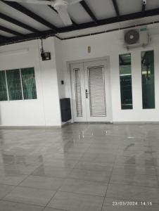 an empty room with white walls and a large tile floor at Batu Pahat Taman Banang Homestay in Batu Pahat