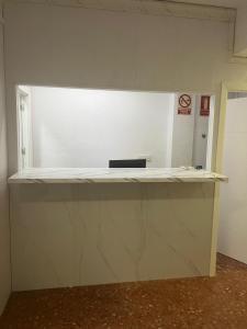 un mostrador en una habitación con una pared blanca en just hostel capsules, en Alicante