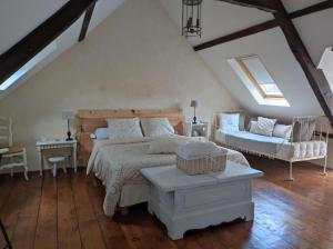 sypialnia z łóżkiem, kanapą i krzesłem w obiekcie Cottage Breton w mieście Les Champs-Géraux