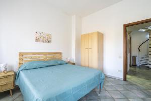 - une chambre avec un lit bleu et une armoire en bois dans l'établissement Casa Grande, à Tortolì