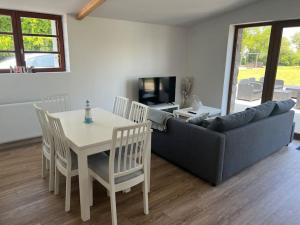 a living room with a couch and a table and chairs at Gîte de caractère in Plurien