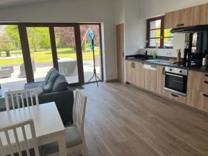 a living room with a couch and a table and a kitchen at Gîte de caractère in Plurien