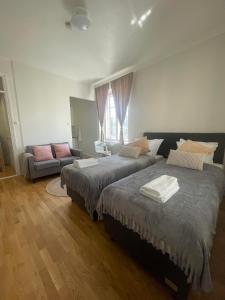 um quarto com 2 camas e um sofá em Your Chic Vibrant Airbnb em Helsínquia