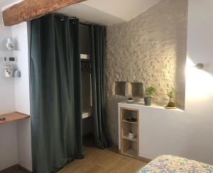 1 dormitorio con cortina verde en una habitación en La Grange de la Brousse en La Brousse