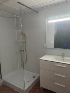 uma casa de banho com uma cabina de duche em vidro e um lavatório. em just hostel capsules em Alicante