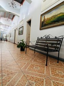 un banc dans un couloir avec une peinture murale dans l'établissement Hotel Barroco, à San José