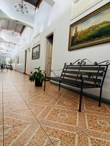a bench in a hallway with a painting on the wall at Hotel Barroco in San José +2 photos