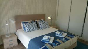 a bedroom with a bed with blue and white pillows at Silver Coast Holiday in Salir de Porto +21 photos