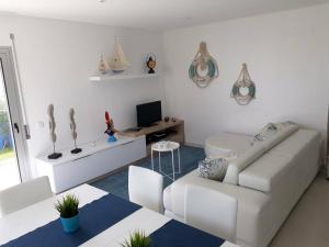 a living room with a white couch and a television at Silver Coast Holiday in Salir de Porto