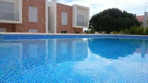 a large blue swimming pool in front of a building at Silver Coast Holiday in Salir de Porto