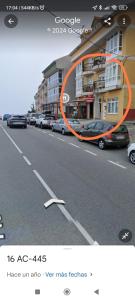 an orange arrow on a street with cars parked at Piso amplio con vistas al mar y playa a 50 mts in Fisterra