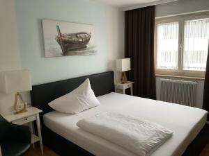 a bedroom with a bed with a white pillow on it at Hotel Berg in Seekirchen am Wallersee