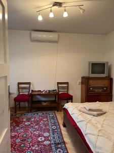 a bedroom with a bed and a table and two chairs at Emese Central Vintage Apartment in Târgu-Mureş