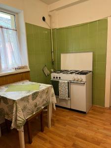 a kitchen with a stove and two tables at Emese Central Vintage Apartment in Târgu-Mureş