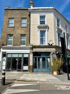 un edificio de ladrillo con puertas azules en una calle en Kings Cross Guest House, en Londres