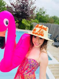 une jeune fille portant un chapeau flamant rose près d'une piscine dans l'établissement le chant de la rivière, à Abbeville