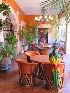 ein Restaurant mit einem Tisch, Stühlen und Pflanzen in der Unterkunft Casa Rosa Amelia in Guadalajara