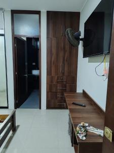 een keuken met houten kasten en een deur naar een badkamer bij Edificio Casuarinas in Piura