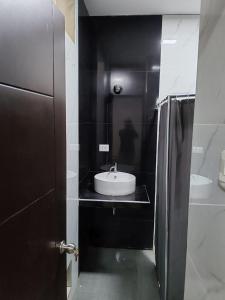 W łazience znajduje się umywalka i lodówka. w obiekcie Edificio Casuarinas w mieście Piura