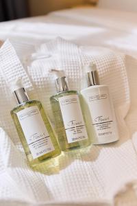 three bottles of soap sitting on top of a bed at Blandford Hotel in London