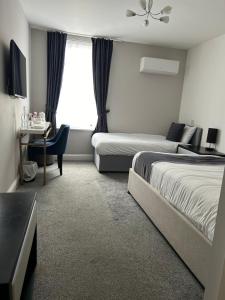 a hotel room with two beds and a window at The Royal Hotel - Clacton On Sea in Clacton-on-Sea