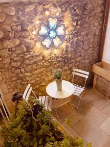 einen Tisch und Stühle in einem Zimmer mit einer Steinmauer in der Unterkunft Le Casette Di Brando E Nico in Tricase