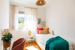 a bedroom with a white bed and a window at Casa Bombón in Sabiñánigo