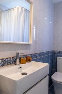 a bathroom with a sink and a mirror and a toilet at Casa Bombón in Sabiñánigo