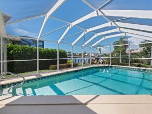 ein Schwimmbecken mit einem darüberliegenden Baldachin in der Unterkunft ELEVATED 106 - Spacious 3 Bedroom Waterside Pool Home in Marco Island