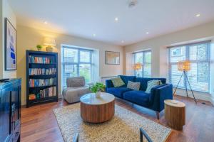 a living room with a blue couch and a table at Weavers Two - Luxury Apartment for Two in Windermere