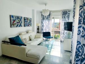 a living room with a white couch and a television at Ático con terraza y barbacoa in Salobreña