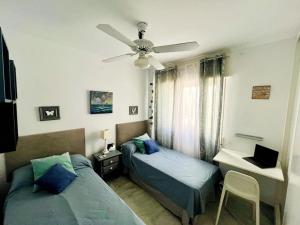a bedroom with two beds and a ceiling fan at Ático con terraza y barbacoa in Salobreña +42 photos