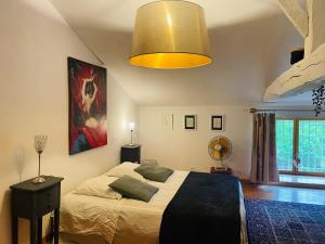 a bedroom with a large bed and a yellow light at Chambres à la campagne in Sauveterre