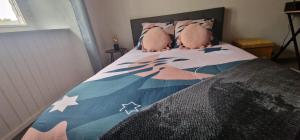 Una cama con dos animales de peluche encima. en Maison de l'Echauguette, en Mortemart