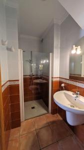 uma casa de banho com um chuveiro, um lavatório e uma banheira em Casa Rosa em Alcalalí