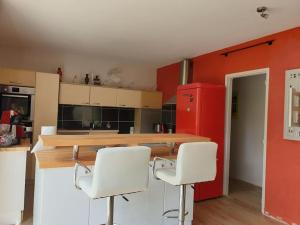 eine Küche mit weißen Stühlen und einem roten Kühlschrank in der Unterkunft Villa indépendante avec piscine in Arès + 9 Fotos