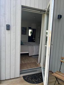 uma porta que leva a um quarto com uma cama em Boende med hotellkänsla i populära Skrea, Falkenberg em Falkenberg