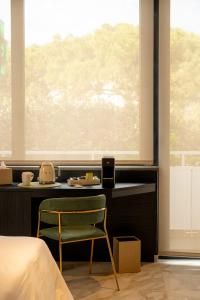 a bedroom with a chair in front of a window at La Duse Luxury Rooms in Pescara +20 photos