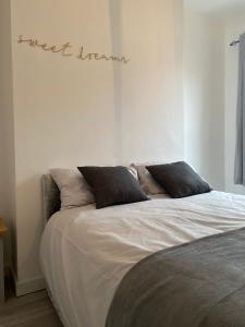 a bed in a bedroom with the words just insane written on the wall at Stylish Home - Close to City Centre, Anfield Stadium - Free Parking in Litherland