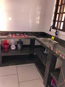 uma cozinha com um lavatório e uma bancada em Casa de praia em Figueira, Arraial do Cabo - Casa Caribe em Arraial do Cabo