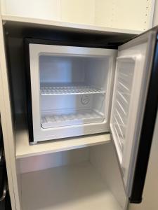 einem leeren Kühlschrank mit offener Tür in der Küche in der Unterkunft Boende med hotellkänsla i populära Skrea, Falkenberg in Falkenberg