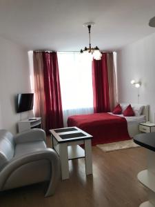 a bedroom with a bed and a chair and a window at Light Apartments in Chernihiv