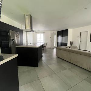 una grande cucina e un soggiorno con divano di Maison 3 chambres avec piscine chauffée a Mios