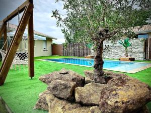 un albero in un cortile accanto a una piscina di Maison 3 chambres avec piscine chauffée a Mios