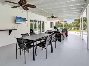 ein Esszimmer mit Tisch und Stühlen und einem Deckenventilator in der Unterkunft ELEVATED 1152 - Serene Family friendly 4 bed pool home in Marco Island