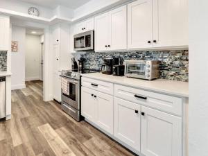 eine weiße Küche mit weißen Schränken und Geräten in der Unterkunft ELEVATED 1152 - Serene Family friendly 4 bed pool home in Marco Island