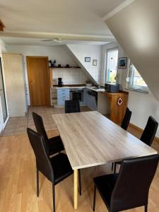 a kitchen and dining room with a wooden table and chairs at Boddenwind FW 2 in Zingst