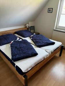 two beds with blue pillows on them in a room at Boddenwind FW 2 in Zingst
