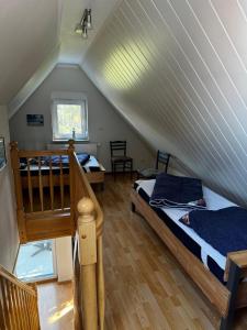 a attic room with two beds and a staircase at Boddenwind FW 2 in Zingst